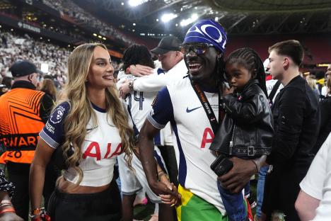 Yves Bissouma celebrates with his girlfriend and child after a soccer victory.