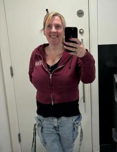 Woman taking a selfie in a restroom mirror.