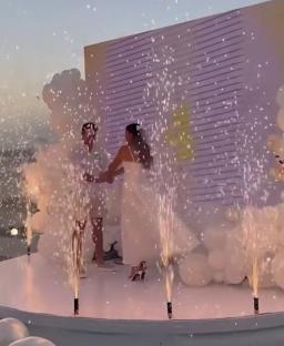 Couple at extravagant gender reveal with fireworks.