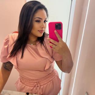 Woman taking a selfie in a pink outfit.