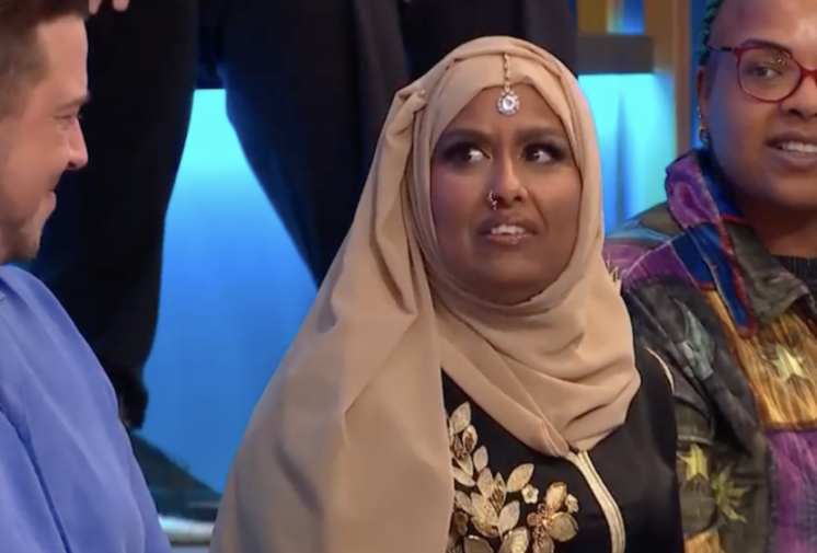 Farida from Big Brother wearing a hijab, looking surprised.