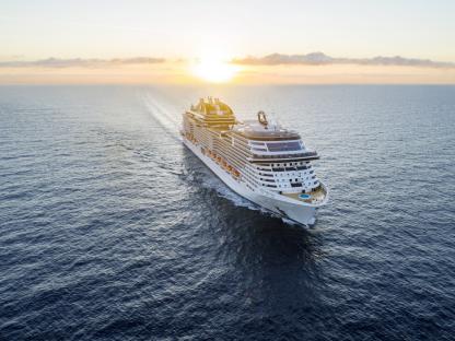 MSC Virtuosa cruise ship sailing at sunset.