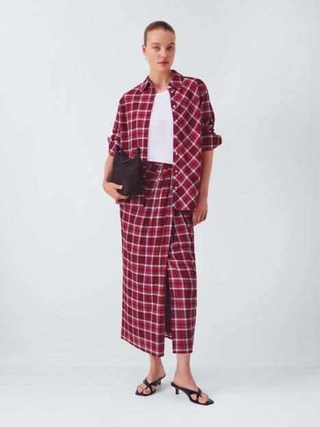 Woman in red plaid shirt and skirt.