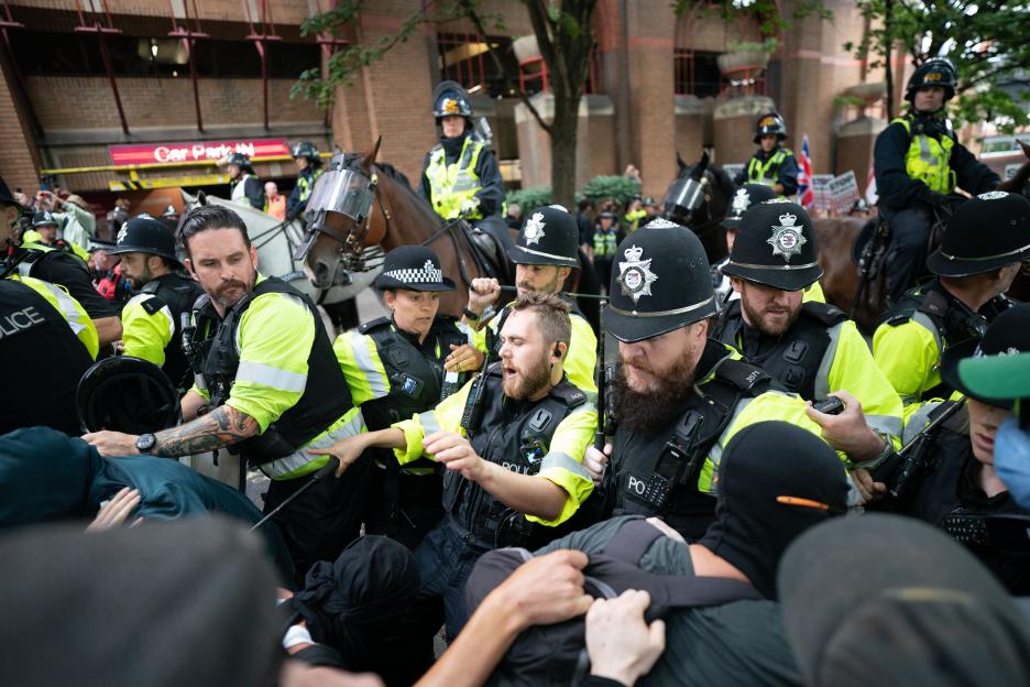 Police officers on horseback clash with protesters.