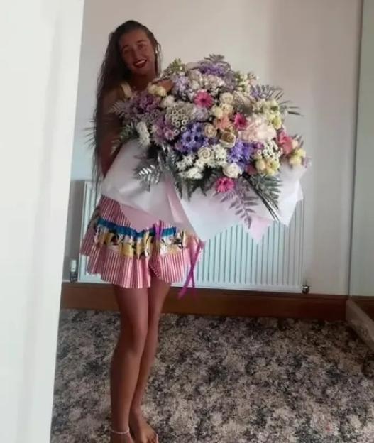 Woman holding a large bouquet of flowers.