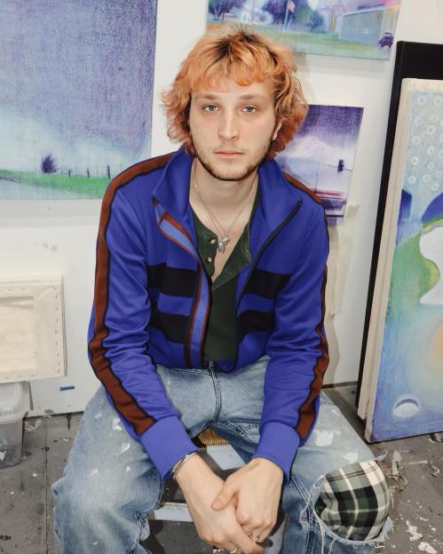 Portrait of a young man sitting in an art studio.