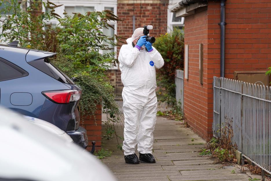 Crime scene investigator photographing a house.