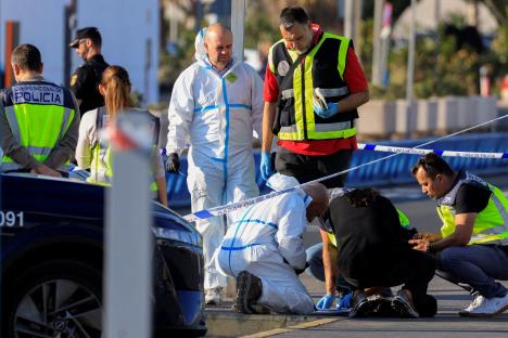 Spanish National Police officers examining documents at a crime scene.
