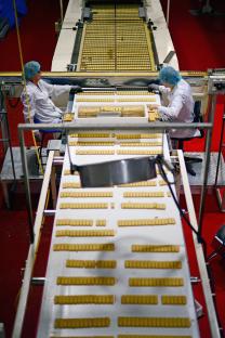 Workers packaging shortbread on a factory assembly line.