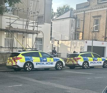 Two police cars parked at a street scene.