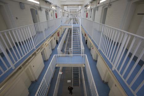 High-angle view of a prison's interior, showing multiple cell blocks and walkways.