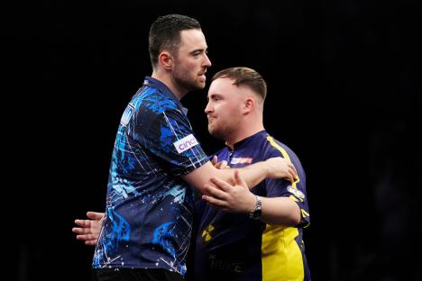 Luke Humphries embracing Luke Littler after a darts match win.