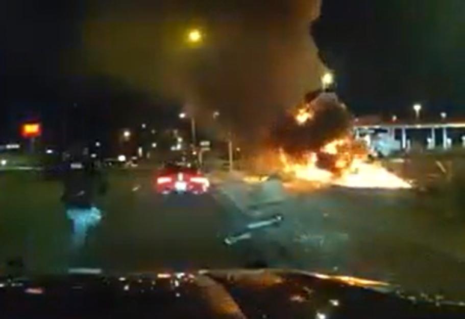 Dashcam view of a car crash resulting in a fiery explosion on a highway at night.