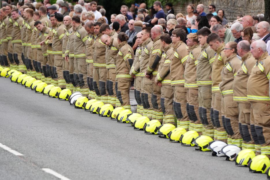 Emotional moment firefighters down helmets as coffin of hero colleague killed in line of duty passes