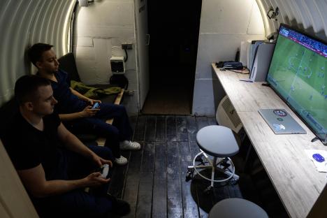 Two men playing video games in a bunker.