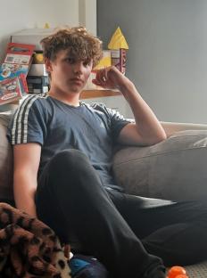 Photo of a teenage boy sitting on a couch.
