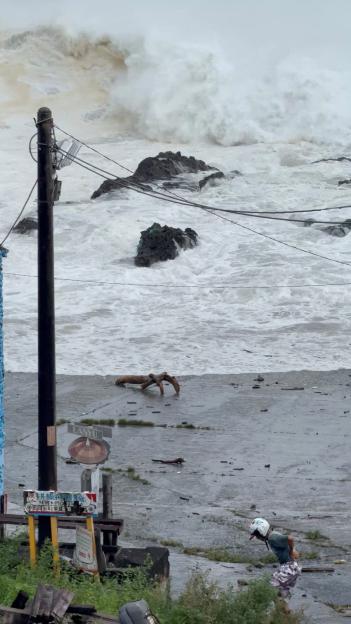 A person walks along the shore as huge waves crash during Super Typhoon Ragasa in Orchid Island, Taiwan.