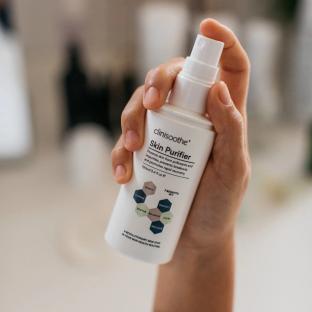 Hand holding Clinisoothe Skin Purifier spray bottle.