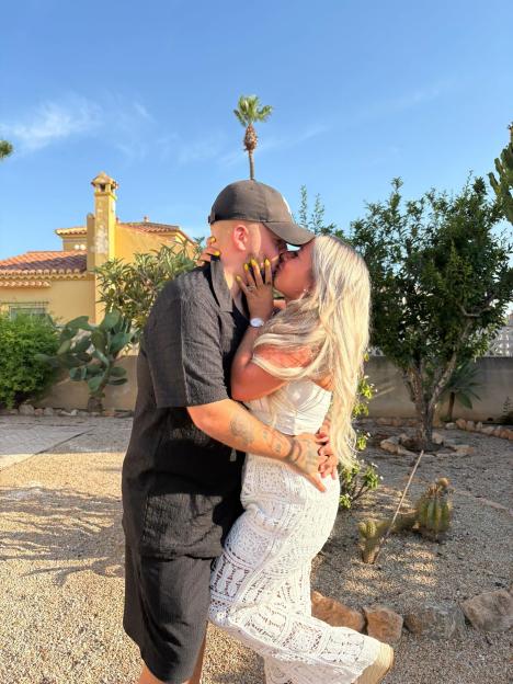 Couple kissing outdoors.