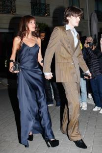 Cruz Beckham and a woman holding hands while leaving a hotel.