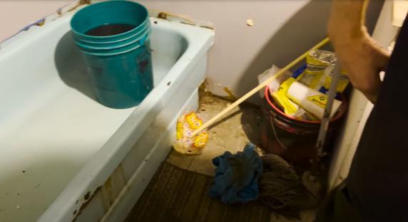 Messy bathroom with cleaning supplies.