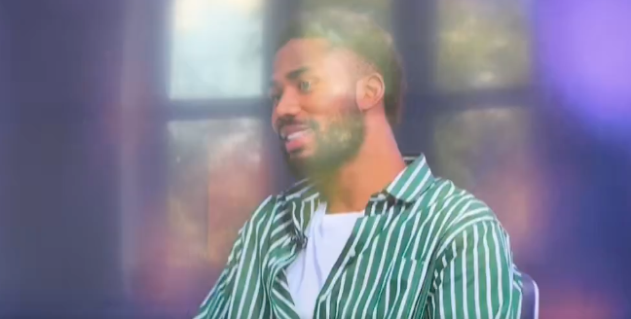 Man in striped shirt smiling.