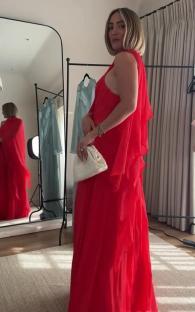 Woman in a red dress holding a white clutch.