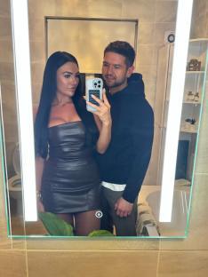 Mirror selfie of a couple in a bathroom.