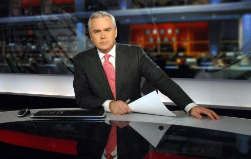 News anchor at a news desk.