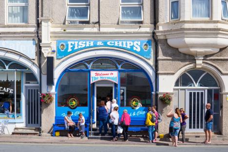 Queue of people outside The Mermaid fish and chips shop.