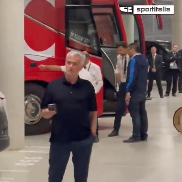 Jose Mourinho holding a phone, waiting in a parking lot.