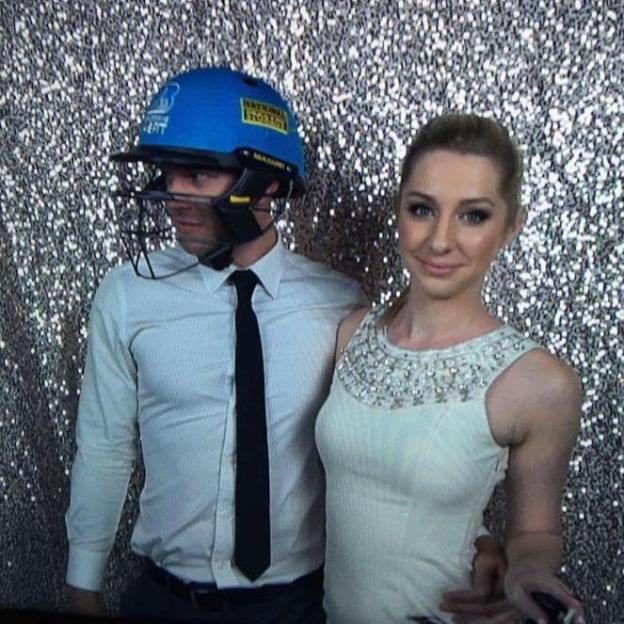 Matt Conwell wearing a blue cricket helmet and Ashleigh Conwell in a white embellished dress.
