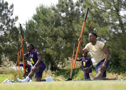 England soccer players stretching with long poles during training.