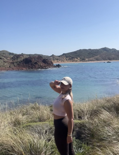 Woman in athletic wear overlooking a bay.