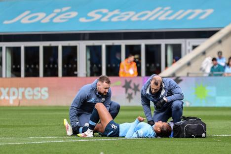 Injured soccer player receiving medical attention on the field.