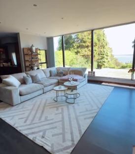 Living room with large windows and sectional sofa.