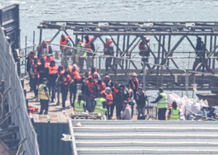 Migrants arriving at a port in life vests.