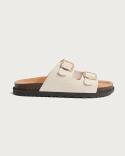 Cream-colored double buckle sandals with cork soles.