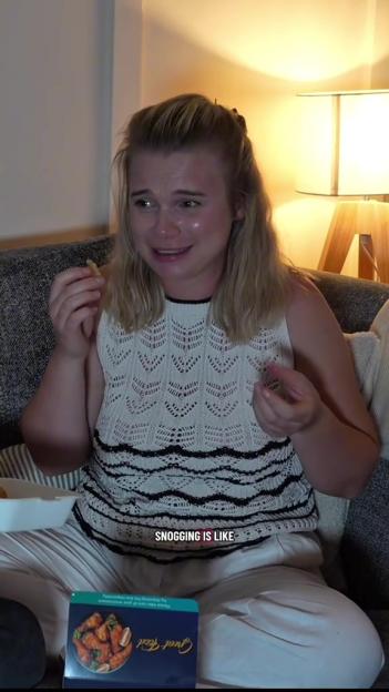 A woman eating on a couch with the text "SNOGGING IS LIKE" displayed on the screen.
