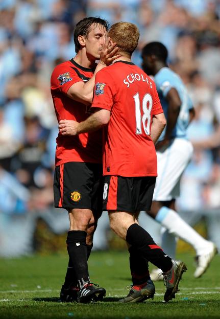 Manchester United teammates Gary Neville and Paul Scholes embracing, Neville kissing Scholes on the side of the head.