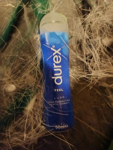 A bottle of Durex Feel Lube on a textured surface.