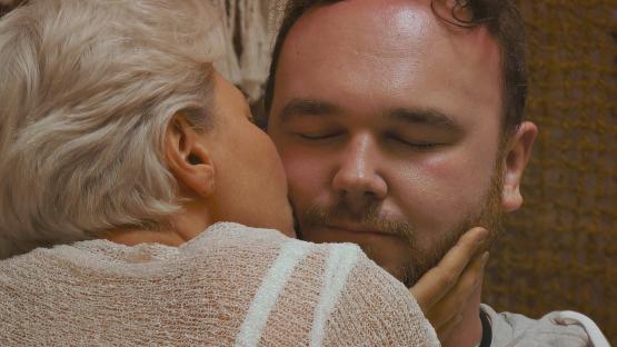 A woman kissing a man on the cheek.