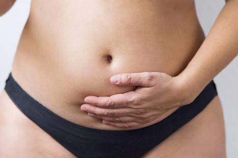 Woman holding her overweight belly.
