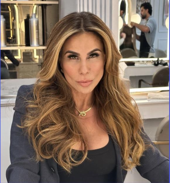 Andrea Sunshine, woman with long brown hair, wearing a black top and necklace.