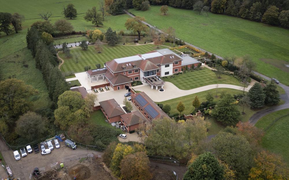 Aerial view of Sunninghill Park, the former home of Prince Andrew, with buildings, manicured lawns, trees, and surrounding green fields.