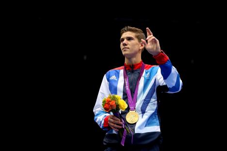 Luke Campbell, Olympic gold medalist, holding a bouquet and his medal.