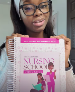 Woman holding a nursing school study guide.