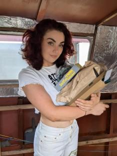 Woman holding packages inside a narrowboat.