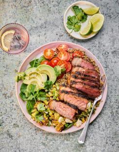 Grilled steak with quinoa, avocado, corn, and cherry tomatoes.