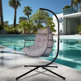 Hanging egg chair with stand by a pool.